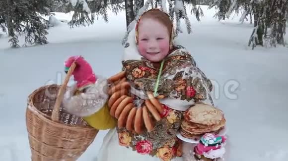 美丽的红发俄罗斯女孩戴着围巾在街上手里拿着一个草篮和煎饼俄罗斯视频的预览图