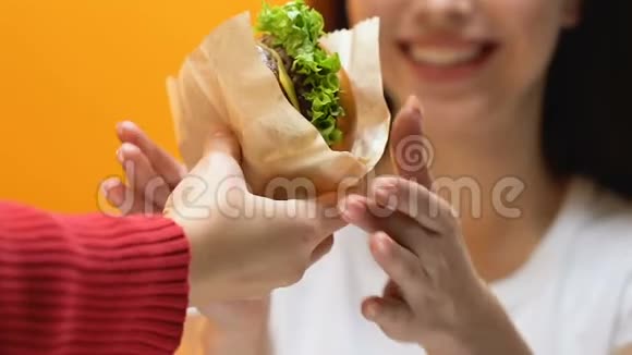 男人给女人带汉堡包年轻的女人贪婪地吃暴食症亲近视频的预览图