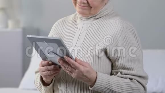 哭的老太太抱着照片想着逝去的人回忆视频的预览图