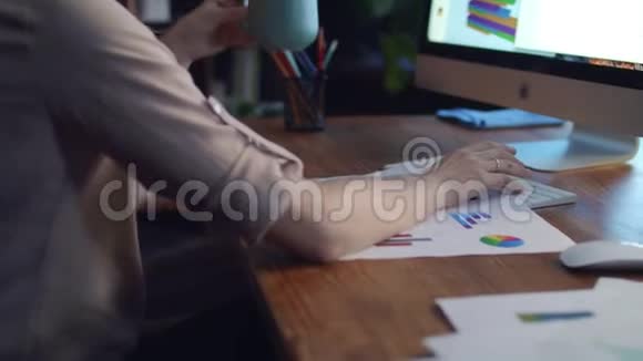 女性手拿着咖啡杯在办公桌后视图中工作视频的预览图