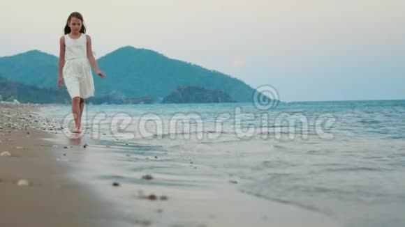 悲伤的女孩独自走在海边慢动作体贴的女孩独自行走视频的预览图