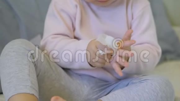 一个可爱的女婴在床上用餐巾擦手视频的预览图