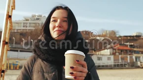 女孩端着一杯咖啡对着蓝天微笑视频的预览图