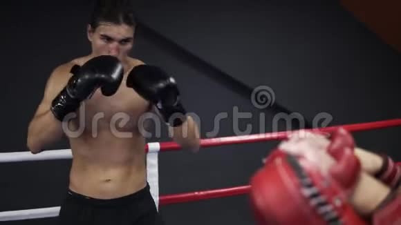 白人穿着黑色衬衫在健身房训练年轻的msn用爪子训练他的腿打拳击视频的预览图