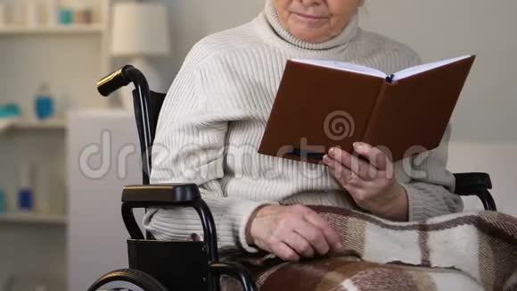 爱看风景的年轻女士给坐在轮椅上看书的老奶奶送眼镜视频的预览图