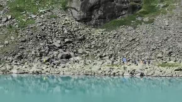 远处的游客走在绿松石风景如画的库伊古克湖边俄罗斯西伯利亚阿尔泰山脉视频的预览图