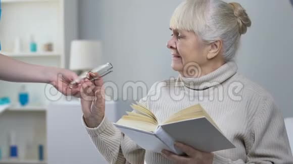 支持护士给老年妇女病人配眼镜老年妇女看书视频的预览图