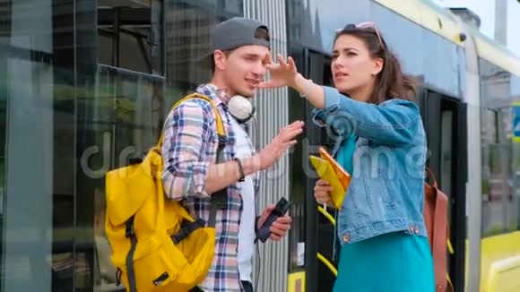 开朗微笑的男人帮助迷路的女孩游客找到路迷路的女游客想办法后台电车站视频的预览图