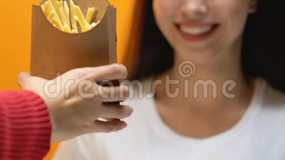 男人在纸箱里给女人炸薯条美国菜送食物视频的预览图