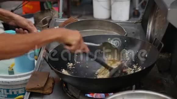 在当地的街头市场上用蔬菜在炒锅里煮薯条米饭4k视频的预览图