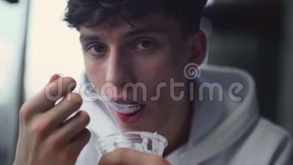 年轻人吃着美味的甜酸奶时的画像微笑着尝试一下视频的预览图