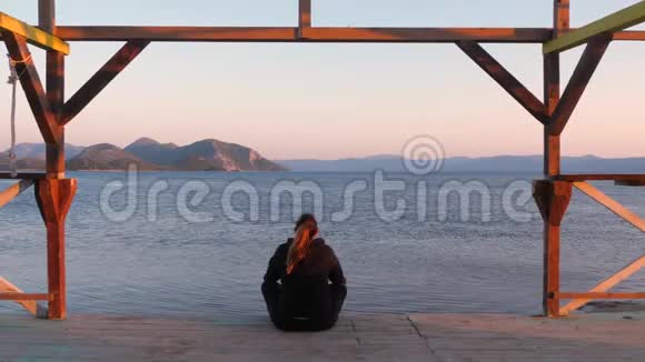 年轻女性在海边的门廊上冥想视频的预览图