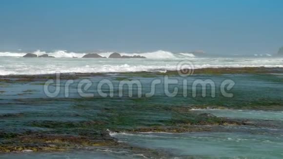 海岸线上棕色岩石上翻滚的海浪图案视频的预览图