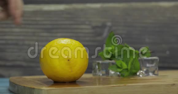 男人在厨房的木切割板上切柠檬视频的预览图