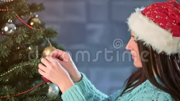 中度特写美女装饰圣诞树挂红球在树枝上视频的预览图