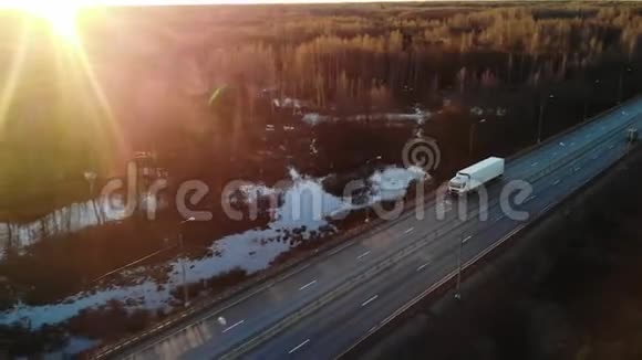 一辆半卡车在高速公路上行驶进入日落前视空中摄像机视频的预览图