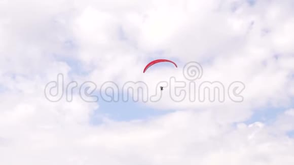 红色降落伞在天空与云运动员在空中飞行滑翔伞视频的预览图
