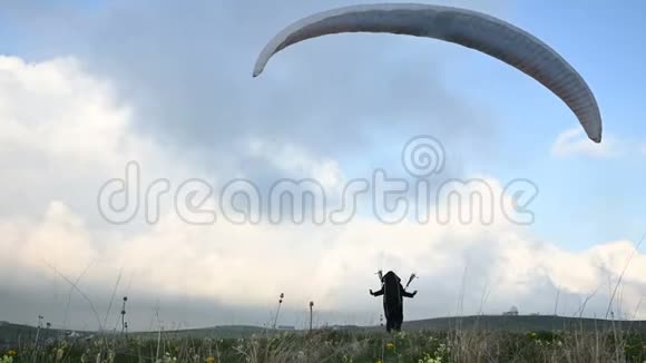 一名男性运动员滑翔伞在黄昏云的背景下在室外升起一只翅膀但不能飞行失败视频的预览图