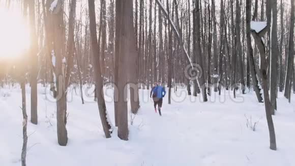 清晨在冬林中奔跑的青年男女美丽的阳光西班牙相机视频的预览图