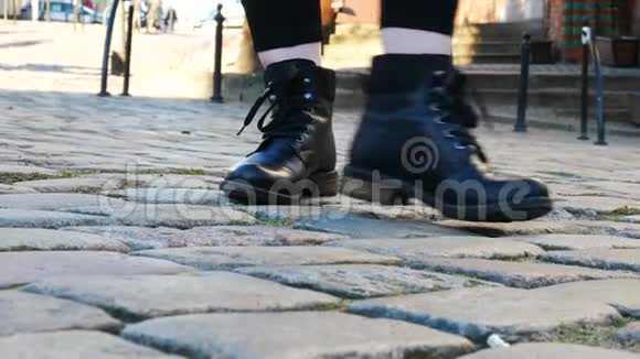 在鹅卵石铺成的路面上穿着黑色靴子的女人紧紧地抱住视频的预览图