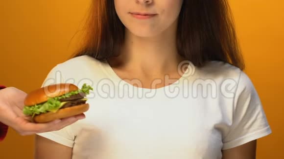 微笑的女士选择绿色沙拉而不是汉堡包健康的饮食理念视频的预览图