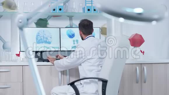 现代办公室或研究中心的博士在用3D脑扫描的电脑工作视频的预览图