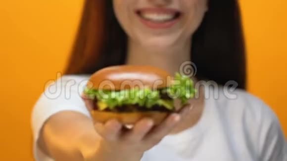 年轻微笑的女士提议美味的汉堡包快餐店关门视频的预览图