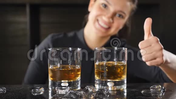 酒吧和鸡尾酒概念穿着黑色制服的女酒保在鸡尾酒和威士忌附近出现拇指成功成功视频的预览图