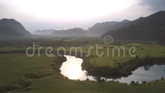 平静的河流在绿色的广阔田野间反射阳光视频的预览图