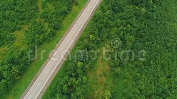 空中俯瞰明亮的汽车在森林里的乡村道路上行驶4K视频的预览图