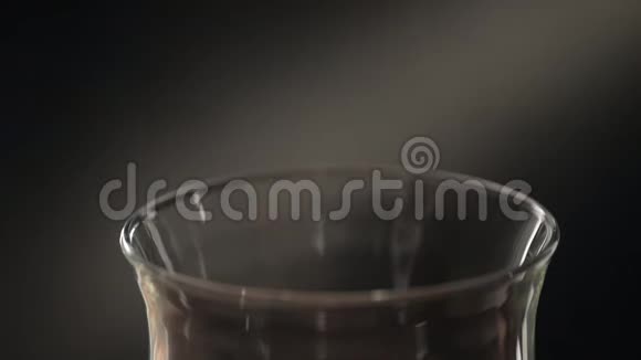用金属过滤器在玻璃杯中酿造茶一个男人的特写手把茶倒进茶过滤器视频的预览图