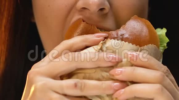 女人厌恶地吃汉堡包拒绝不健康的垃圾食品关门视频的预览图