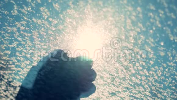 情人节那天一只美丽的雌性手在覆盖着雪的冰冻汽车挡风玻璃上画心形符号视频的预览图