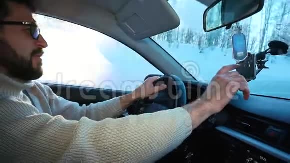 一个人在高速公路上开车他选择了导航仪中的路线在智能手机上连接到视频的预览图