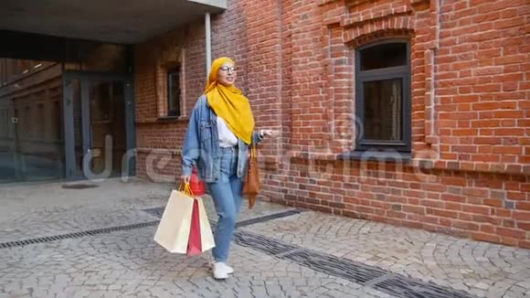 年轻漂亮的穆斯林妇女购物后拿着购物袋视频的预览图