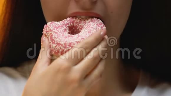 有吸引力的糖瘾妇女吃釉面甜甜圈有糖尿病的风险关闭视频的预览图