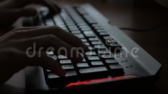 在键盘上打字男人手印在黑暗办公室的键盘上视频的预览图