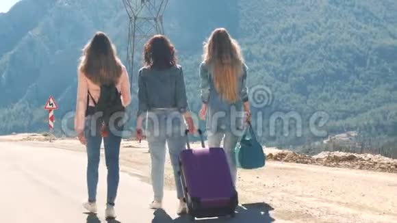 三个年轻女孩走在路上带着美丽的自然景观视频的预览图