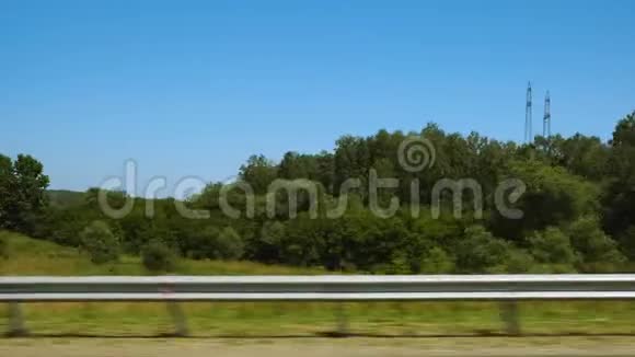绿色的田野与树木从移动的汽车挡风玻璃视频的预览图