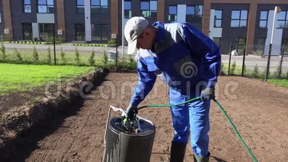 专业的园艺师用软管中的水填充土壤滚筒静态射击视频的预览图