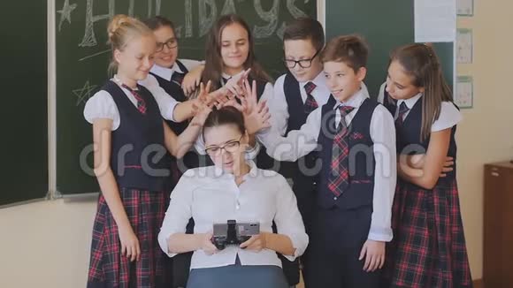 穿校服的学生正站在一位坐在椅子上打电话的老师旁边概念视频的预览图