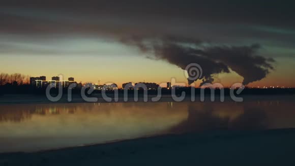 日落时分在美丽的河流的背景下城市里有工厂视频的预览图