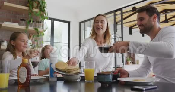 家庭在舒适的家中厨房的餐桌上有食物视频的预览图
