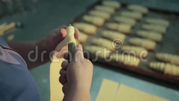 糖果女手正在转动不锈钢管制作羊角面包视频的预览图