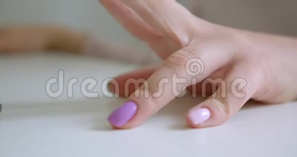 用美甲手指敲击桌子的女性手的特写镜头视频的预览图