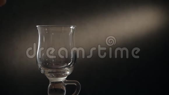 用金属过滤器在玻璃杯中冲泡茶一个男人的特写手把茶倒进茶过滤器视频的预览图