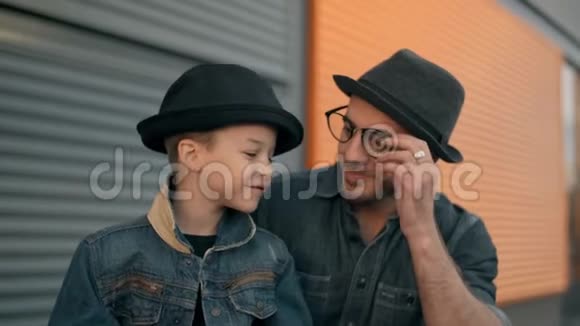 爸爸和小儿子在户外玩耍的时候一边聊天一边微笑视频的预览图