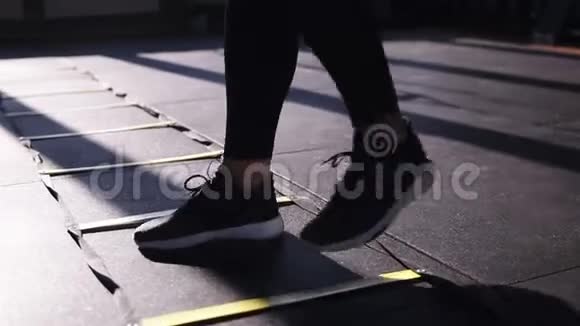 穿黑色紧身裤的女人在健身房训练同时在地板上的运动中在分开的部分上踏步后退和前进视频的预览图