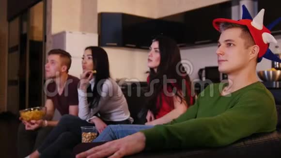 四个年轻人看电视和翻动电视频道视频的预览图