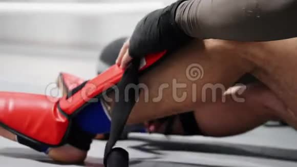 拳击运动员男子拳击手运动服拳击前用双腿绑上绷带身穿红腿盾牌的士兵视频的预览图